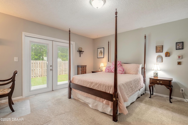 carpeted bedroom with access to exterior, a textured ceiling, and french doors