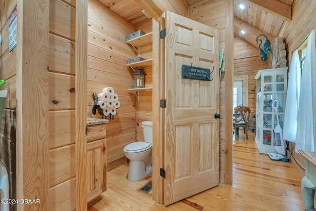 bathroom with lofted ceiling with beams, wood walls, wood ceiling, and wood-type flooring