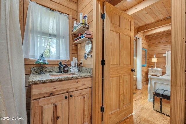 bathroom with wood ceiling, hardwood / wood-style floors, wooden walls, vanity, and beam ceiling