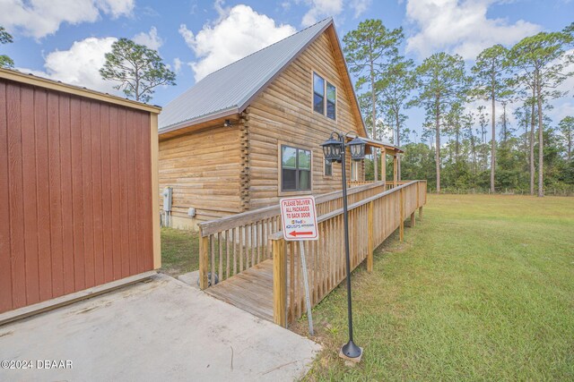 view of side of home with a lawn and a deck