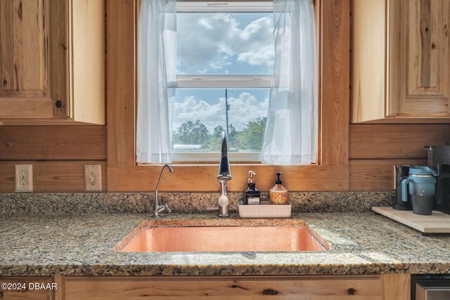 room details featuring light stone countertops and sink