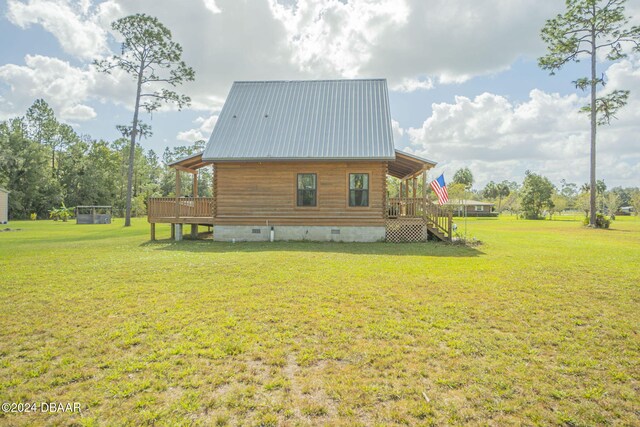 view of side of property with a yard and a wooden deck