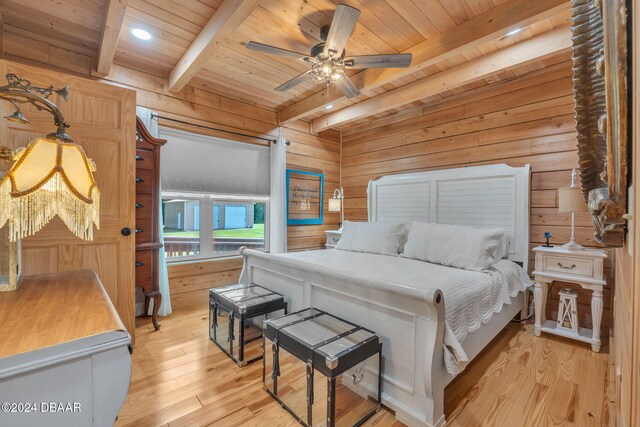 bedroom featuring wooden walls, light hardwood / wood-style floors, beamed ceiling, wooden ceiling, and ceiling fan