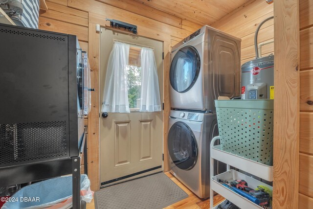 washroom with hardwood / wood-style floors, water heater, wood walls, wooden ceiling, and stacked washer and dryer