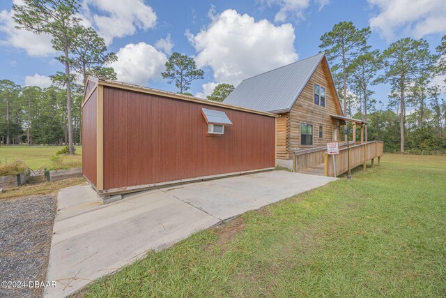 view of side of property featuring a lawn and a deck