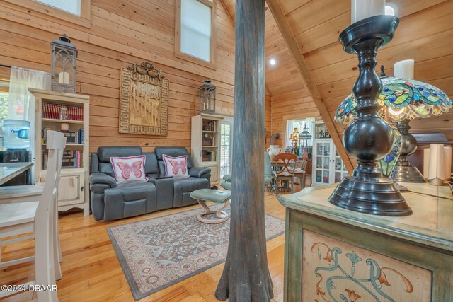 living room with wood walls, beamed ceiling, a skylight, wood-type flooring, and wood ceiling