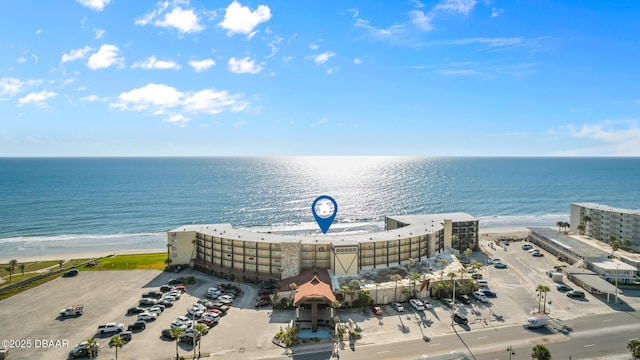 drone / aerial view with a water view and a beach view