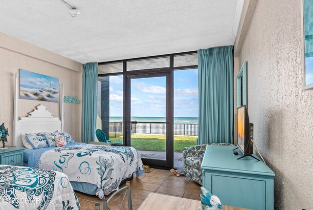 2301 S Atlantic Ave Unit 132, Daytona Beach, FL 32118 - bedroom with access to outside, expansive windows, a textured ceiling, and a textured wall