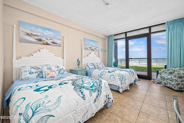 2301 S Atlantic Ave Unit 132, Daytona Beach, FL 32118 - bedroom with a wall of windows, access to outside, light tile patterned flooring, and a textured ceiling