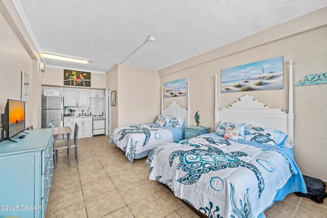 2301 S Atlantic Ave Unit 132, Daytona Beach, FL 32118 - bedroom featuring freestanding refrigerator, light tile patterned flooring, and a textured ceiling