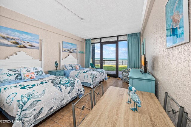 2301 S Atlantic Ave Unit 132, Daytona Beach, FL 32118 - tiled bedroom featuring access to outside, floor to ceiling windows, a textured ceiling, and a textured wall