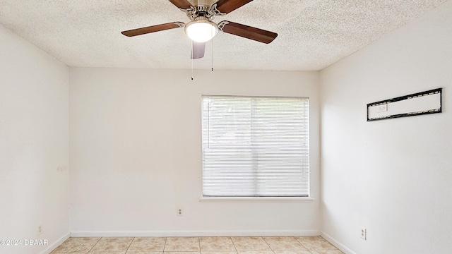 tiled spare room with a textured ceiling and ceiling fan