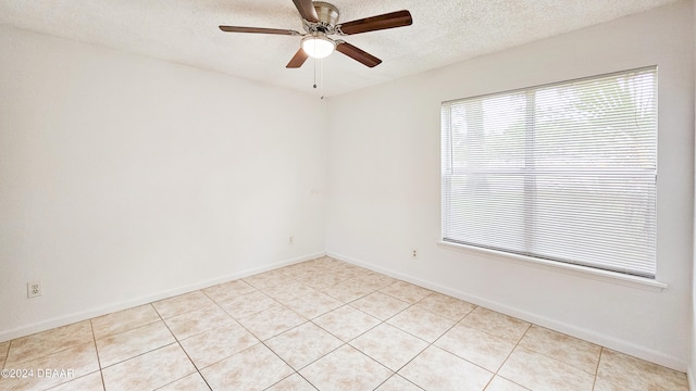 tiled spare room with a textured ceiling and ceiling fan