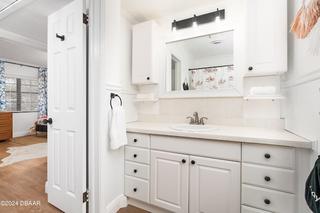 bathroom with hardwood / wood-style flooring, vanity, and crown molding