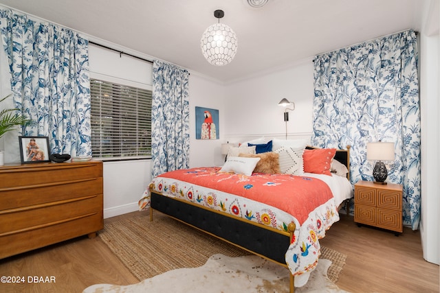 bedroom featuring light hardwood / wood-style flooring and crown molding