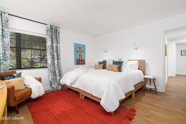 bedroom with hardwood / wood-style flooring and ornamental molding