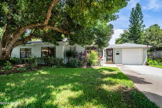 single story home featuring a front yard and a garage