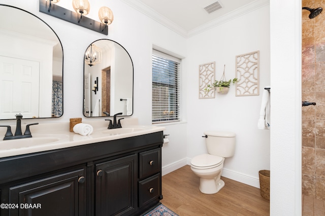 bathroom with tiled shower, crown molding, vanity, hardwood / wood-style flooring, and toilet