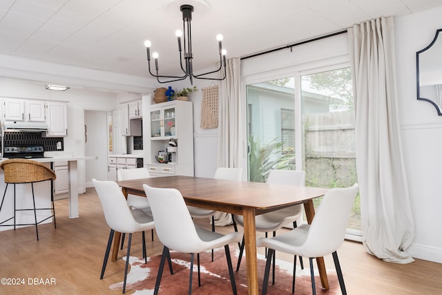 dining area with light wood-type flooring and a chandelier