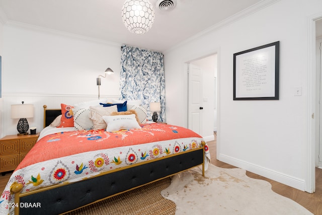 bedroom with hardwood / wood-style flooring and crown molding