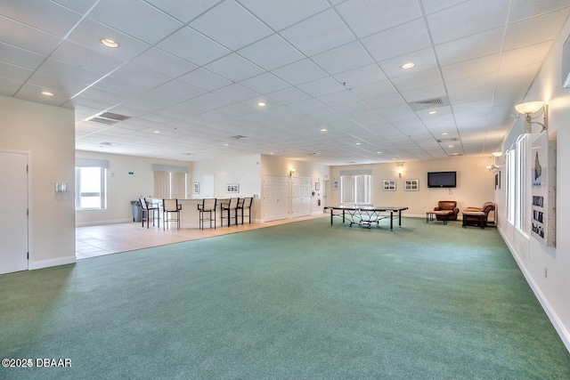 playroom with a paneled ceiling and carpet