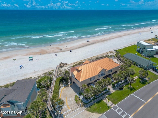 birds eye view of property with a water view and a beach view