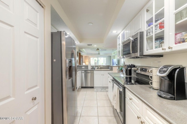 kitchen featuring sink, stainless steel appliances, white cabinets, and light tile patterned flooring