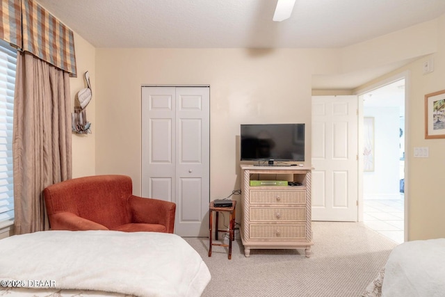 bedroom with light carpet, ceiling fan, and a closet