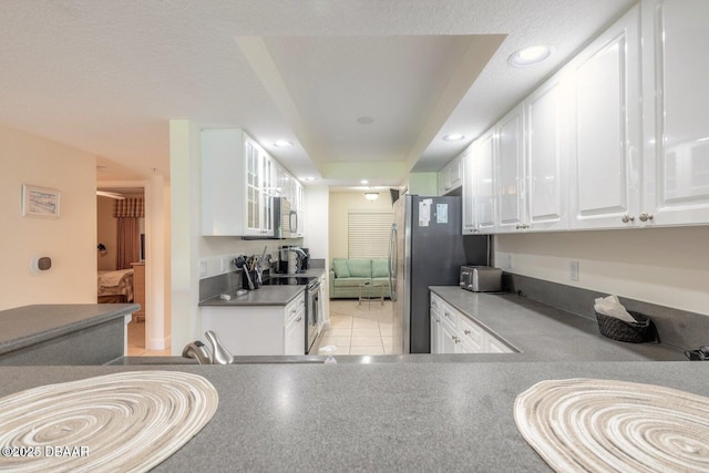 kitchen with appliances with stainless steel finishes, light tile patterned floors, and white cabinets