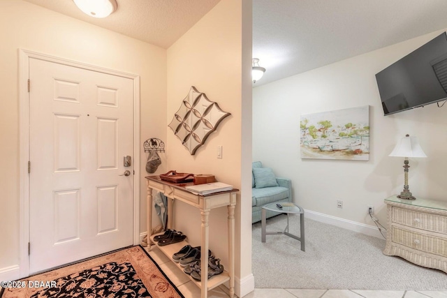 carpeted entryway with a textured ceiling