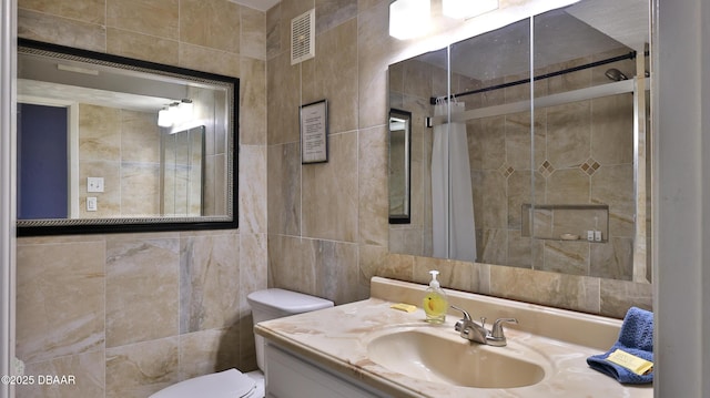 bathroom featuring toilet, vanity, tile walls, and walk in shower