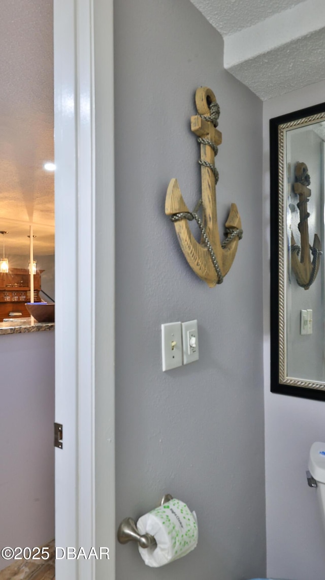 bathroom with a textured ceiling and toilet