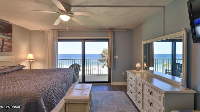 bedroom featuring access to exterior, a water view, multiple windows, and ceiling fan