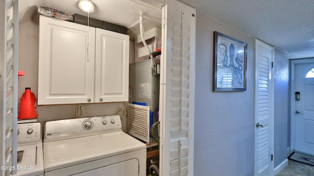 washroom with cabinets, independent washer and dryer, and a textured ceiling