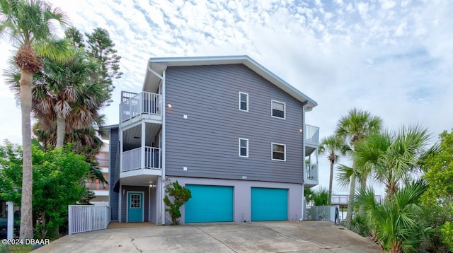 view of side of property featuring a garage and a balcony