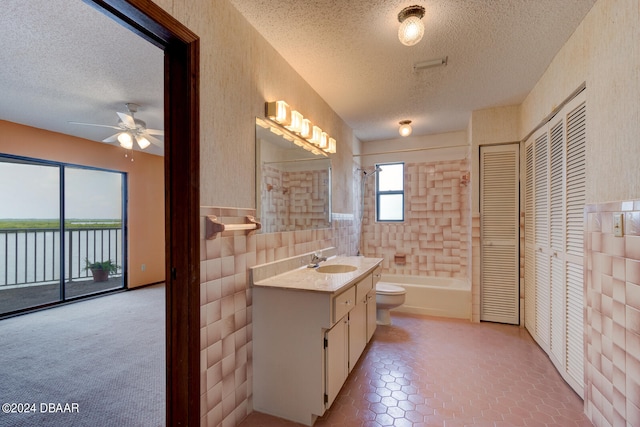 full bathroom with vanity, a textured ceiling, a water view, and tile walls