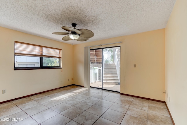 unfurnished room with light tile patterned flooring, ceiling fan, and a textured ceiling