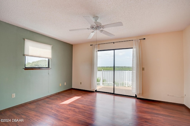 unfurnished room with dark wood-type flooring, a textured ceiling, and ceiling fan