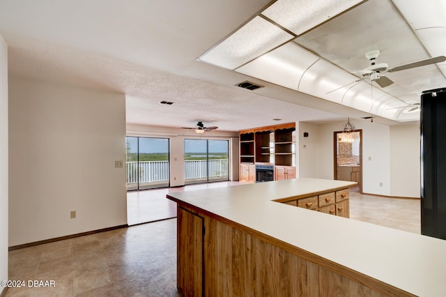 kitchen with a textured ceiling and ceiling fan