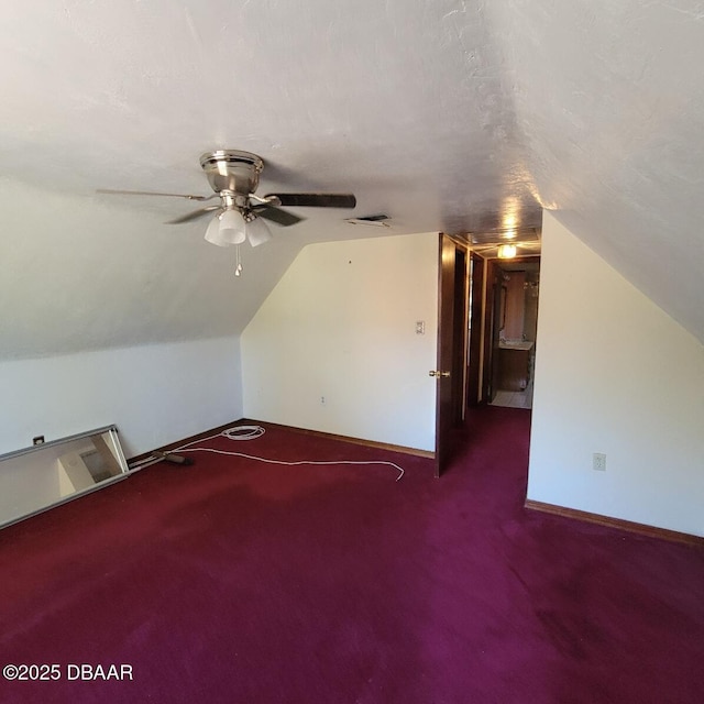 bonus room featuring a ceiling fan, a textured ceiling, baseboards, carpet floors, and lofted ceiling