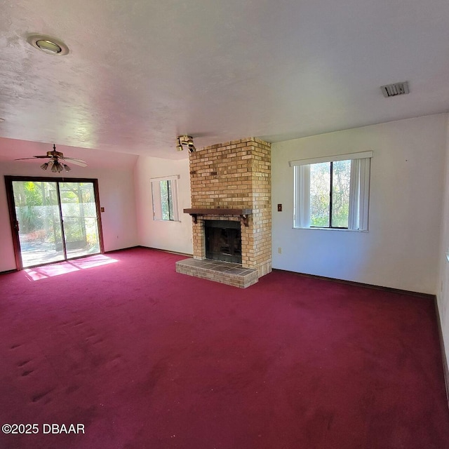 unfurnished living room featuring a wealth of natural light, visible vents, and carpet