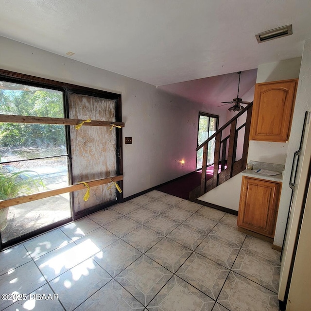 interior space featuring stairway, light tile patterned floors, visible vents, and ceiling fan