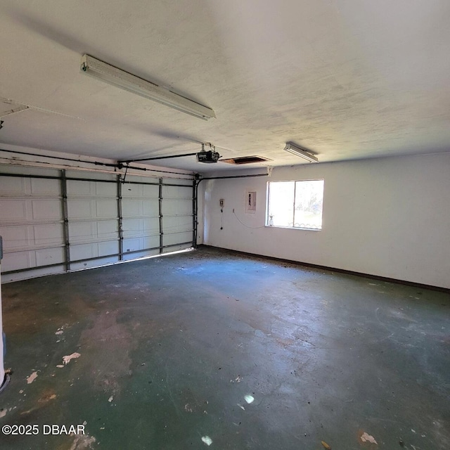 garage featuring a garage door opener and baseboards