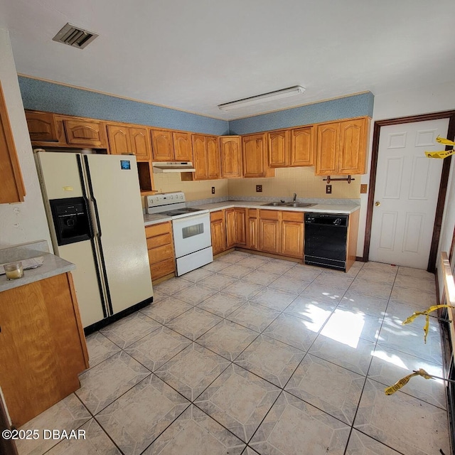 kitchen featuring visible vents, under cabinet range hood, a sink, white appliances, and light countertops