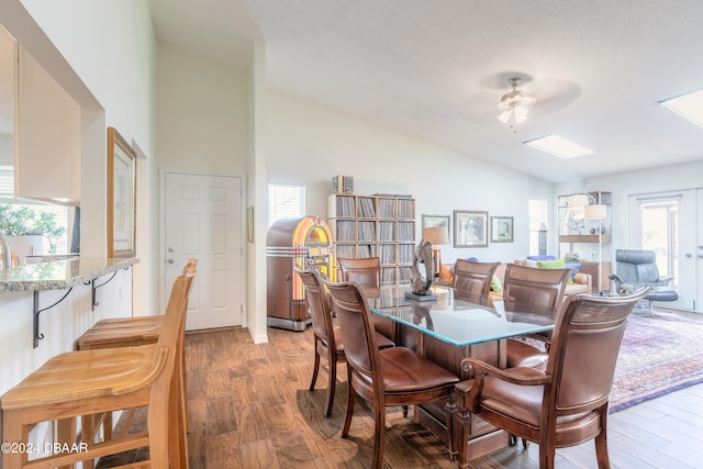 dining space featuring high vaulted ceiling, wood-type flooring, and ceiling fan