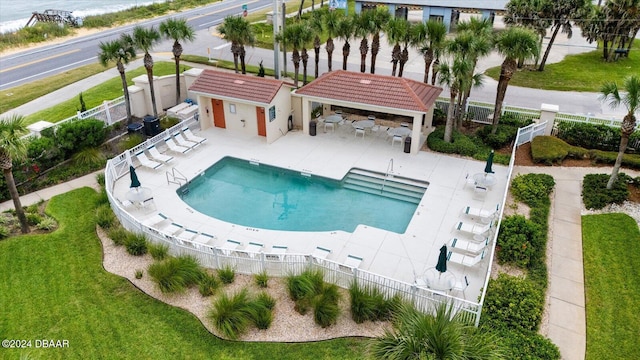 view of pool with a gazebo, a water view, a patio area, and an outdoor structure