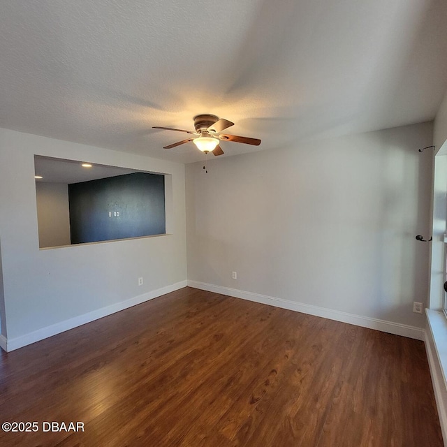 spare room with baseboards, a textured ceiling, wood finished floors, and a ceiling fan