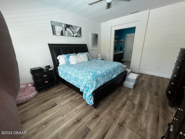 bedroom with hardwood / wood-style floors, ceiling fan, and connected bathroom