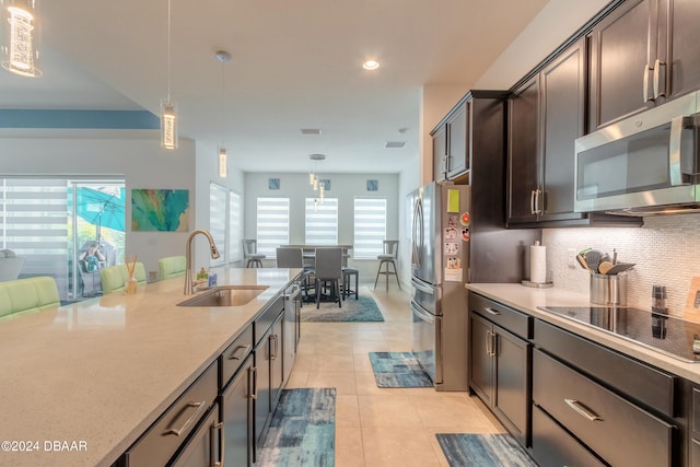 kitchen featuring pendant lighting, stainless steel appliances, sink, and dark brown cabinets