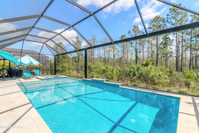 view of swimming pool featuring glass enclosure and a patio area